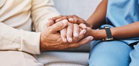Image of nurse and patient holding hand