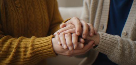 People holding hands whilst sitting down