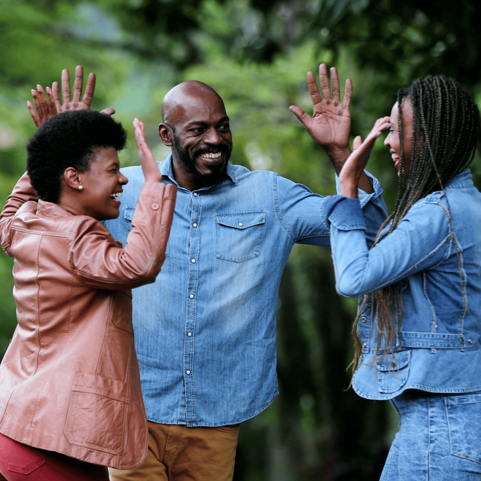 Three friends high fiving with big smiles