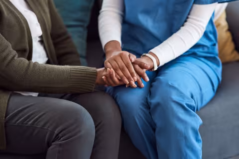 Female nurse holding the hands of a patient