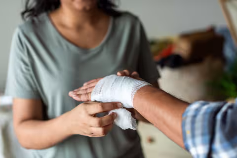 Woman dresses a patients' hand with a bandage 