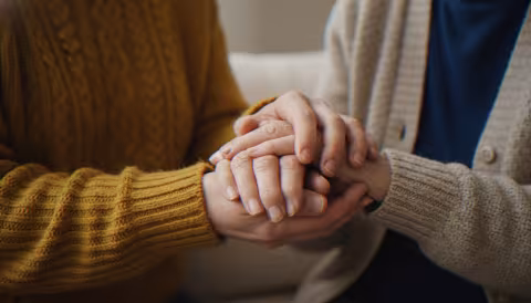 People holding hands whilst sitting down