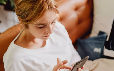 Woman sat on a chair looking at her phone