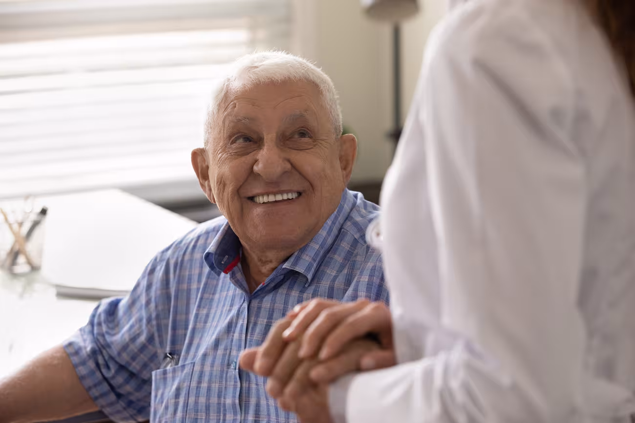Old man holding hands with his nurse
