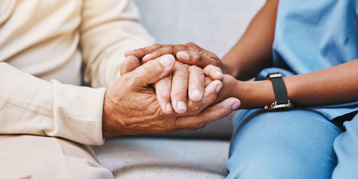 Image of nurse and patient holding hand