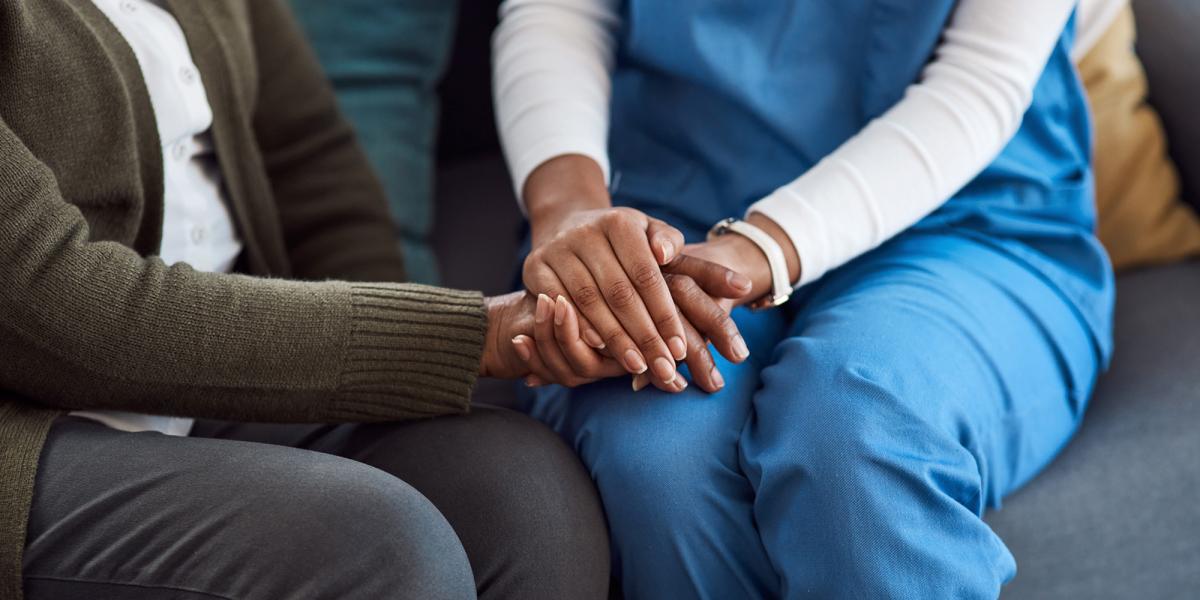 Female nurse holding the hands of a patient