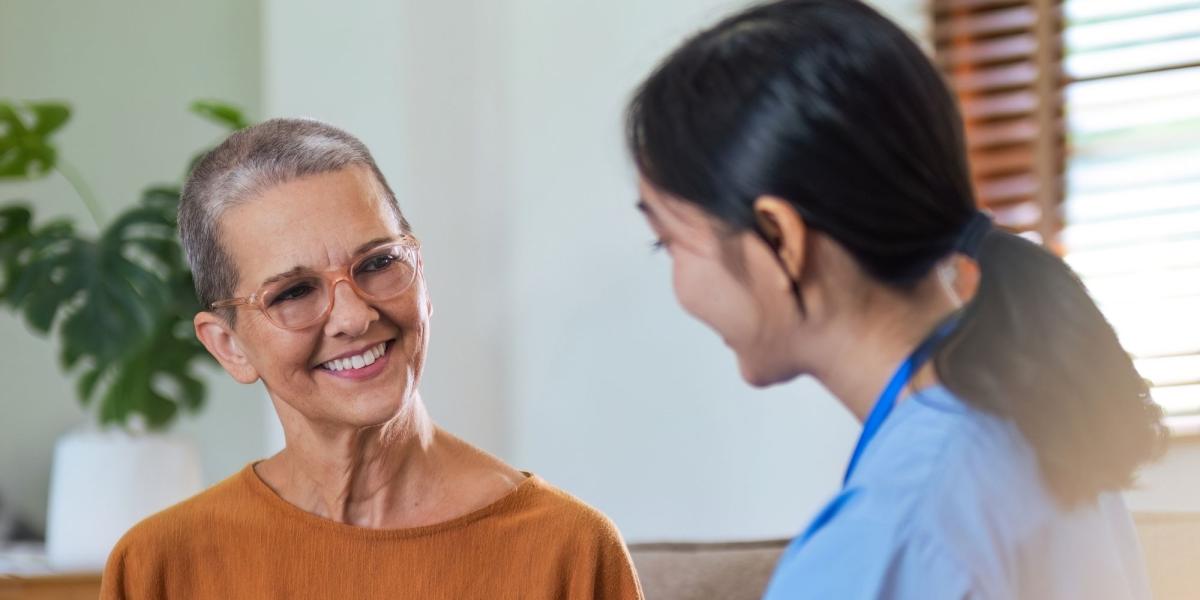 Patient holding hands with a supportive clinician, sat down on a sofa