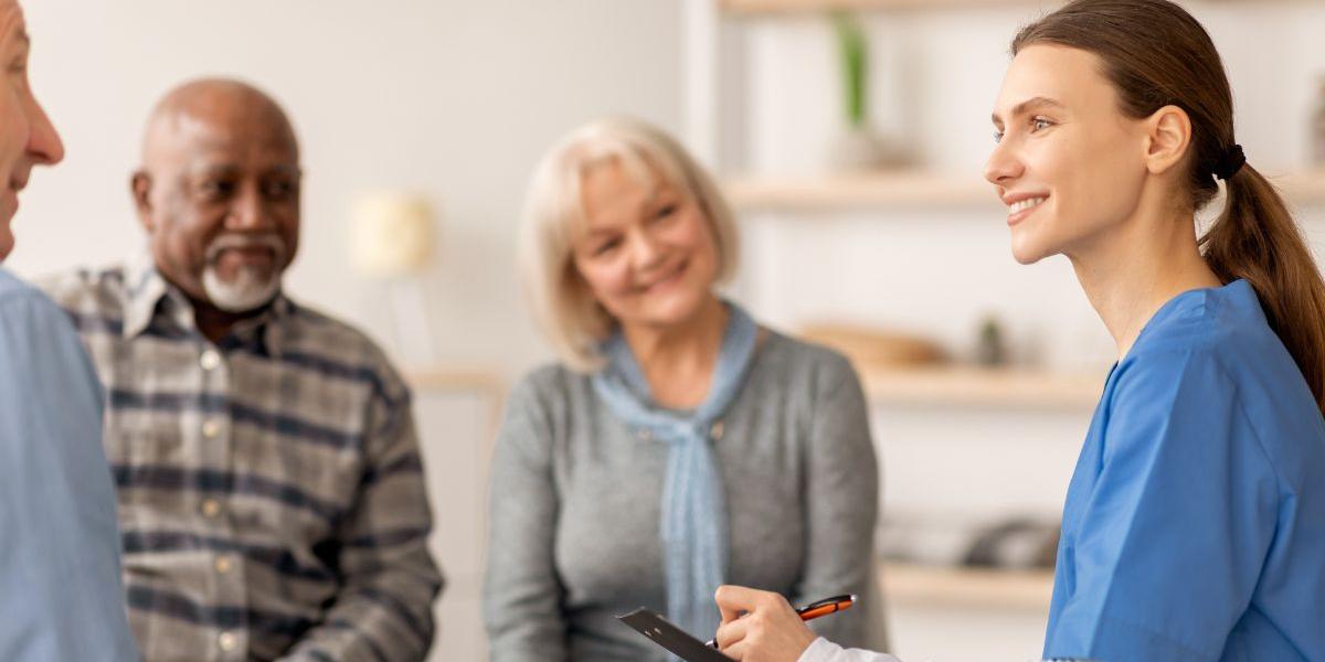 Female clinician talking with a group of people in a white room