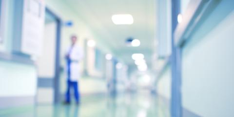 Blurred photograph of a hospital with staff walking in the hallway