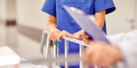 doctor with clipboard and nurse by hospital bed