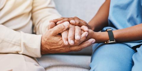 Image of nurse and patient holding hand