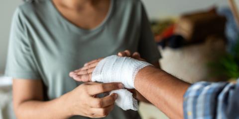 Woman dresses a patients' hand with a bandage 