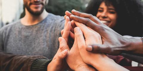 People touching hands in circle