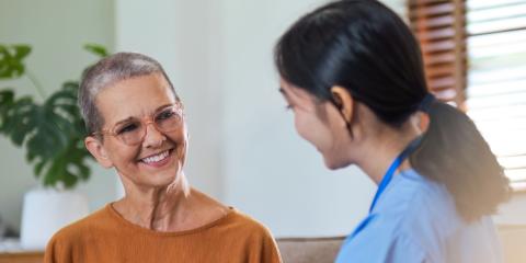 Patient holding hands with a supportive clinician, sat down on a sofa