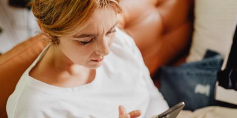 Woman sat on a chair looking at her phone