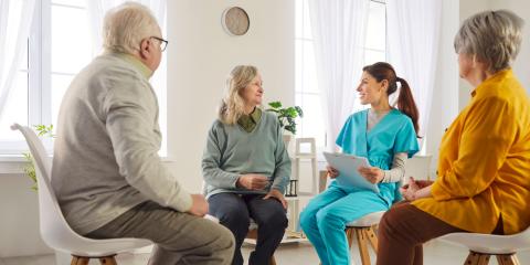 People talking with a clinician, sat down in a circle 